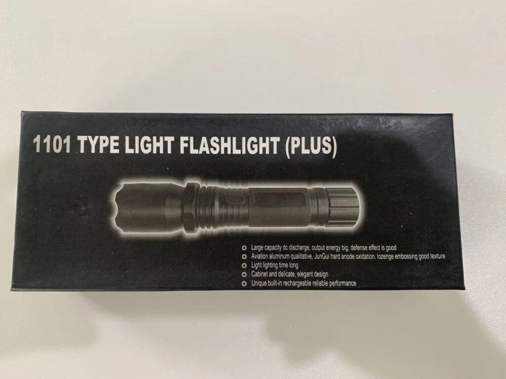 Lampe de poche auto-défense noire avec fonction taser électrique, dimensions compactes.